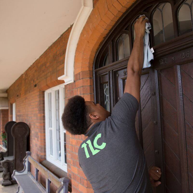 TLC window cleaner thoroughly cleaning window frames and sills as part of a complete window cleaning service.