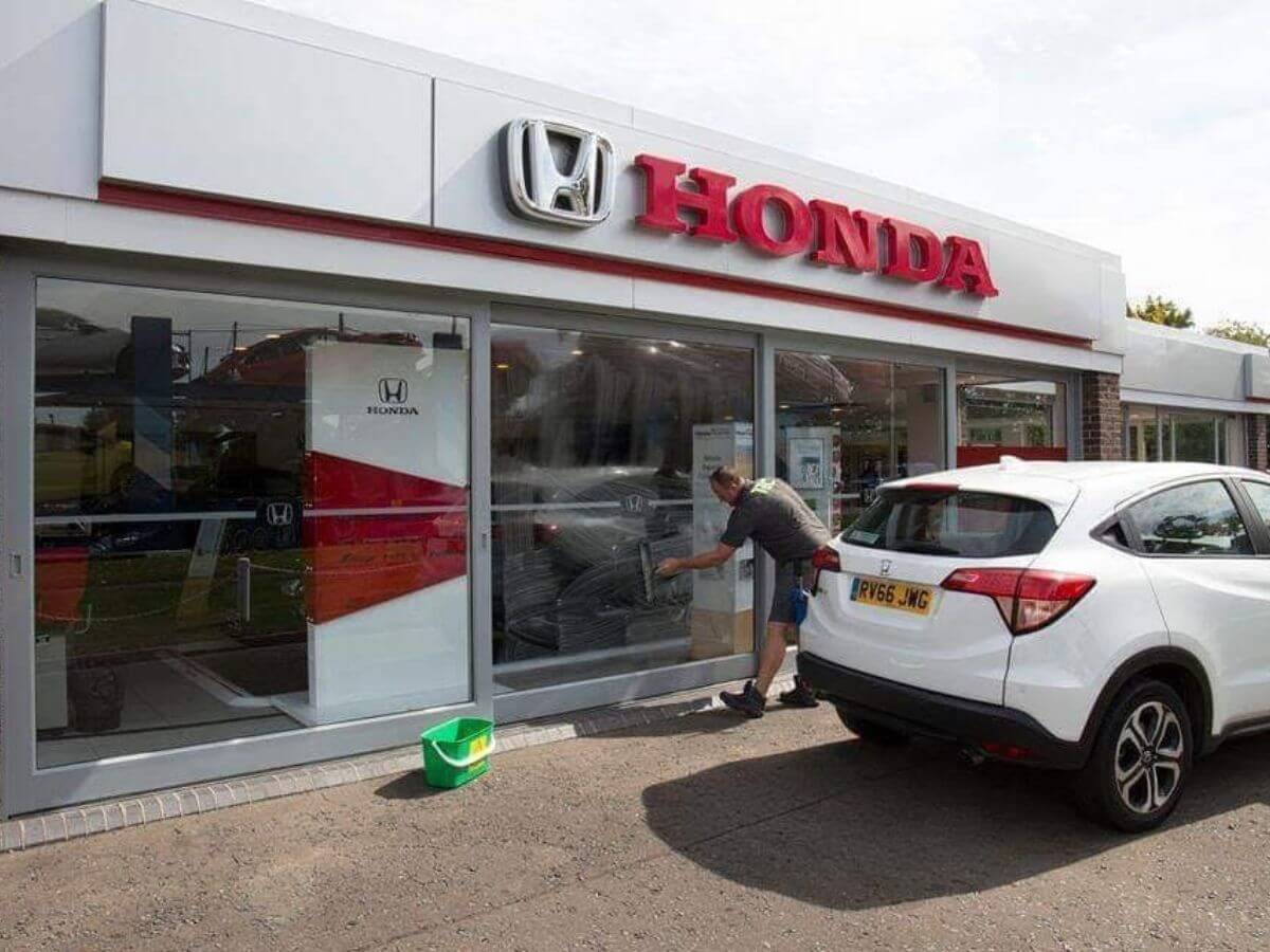 Commercial window cleaning being carried out at a Honda dealership with minimal disruption to business operations.