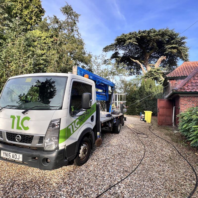 TLC branded specialist vehicle and access equipment at a residential roof cleaning project.