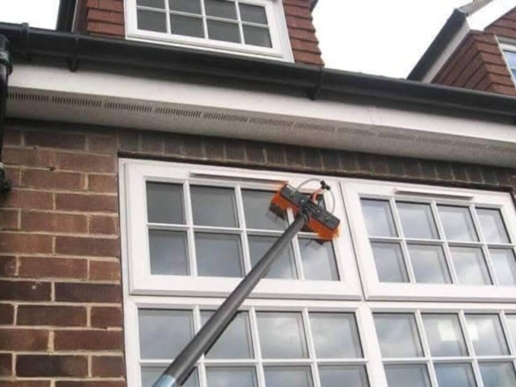 Water fed pole cleaning windows on a traditional brick residential property